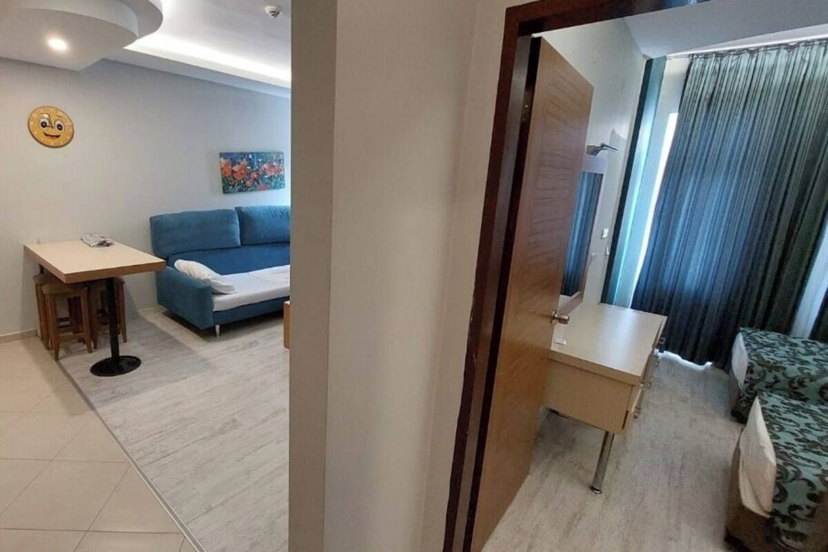 A compact living space with a sofa, a small table, and a bed.