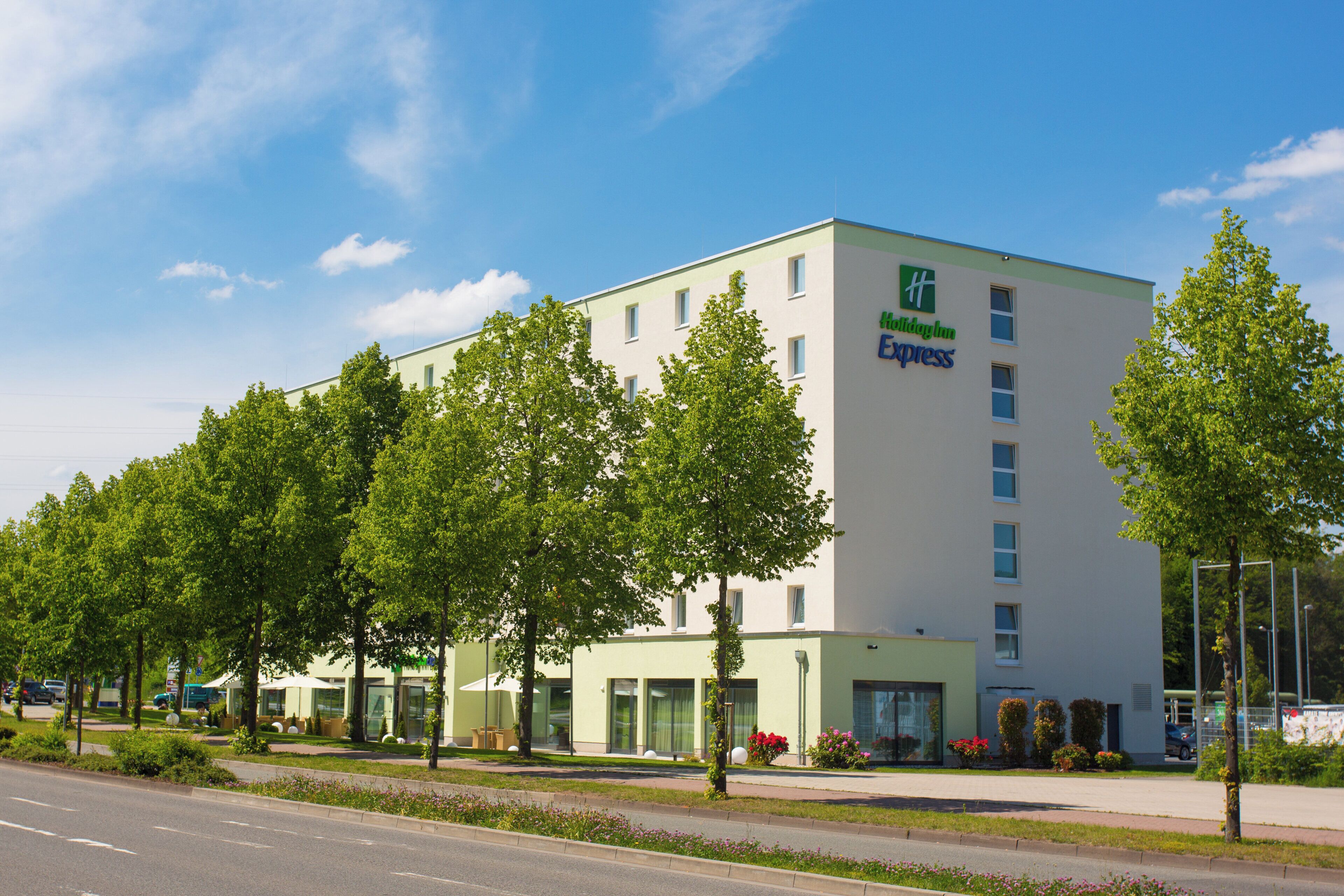 Un hôtel Holiday Inn Express doté d’une façade moderne, de nombreuses fenêtres et d’un toit plat.