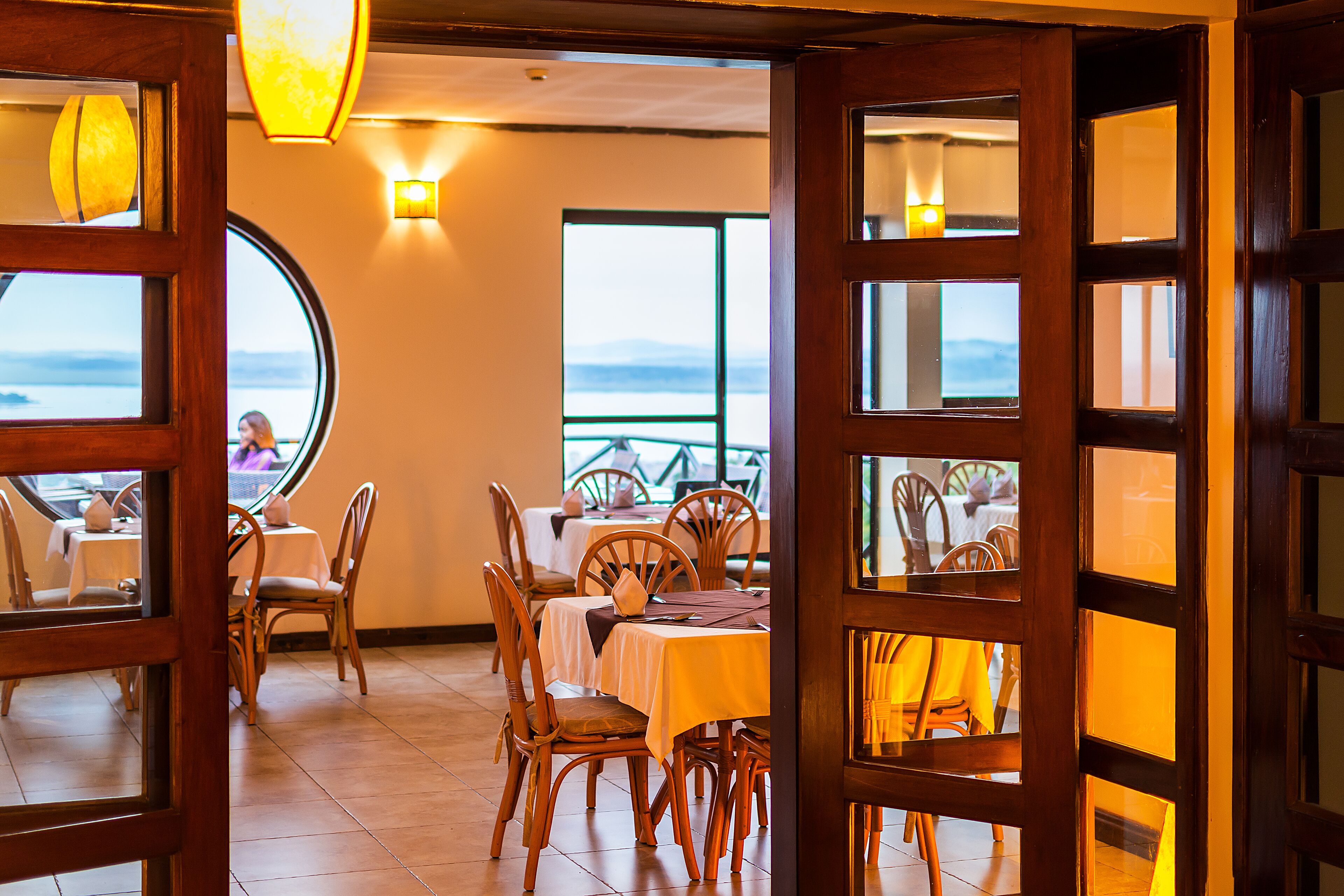 A restaurant with wooden furniture and a view of the sea.