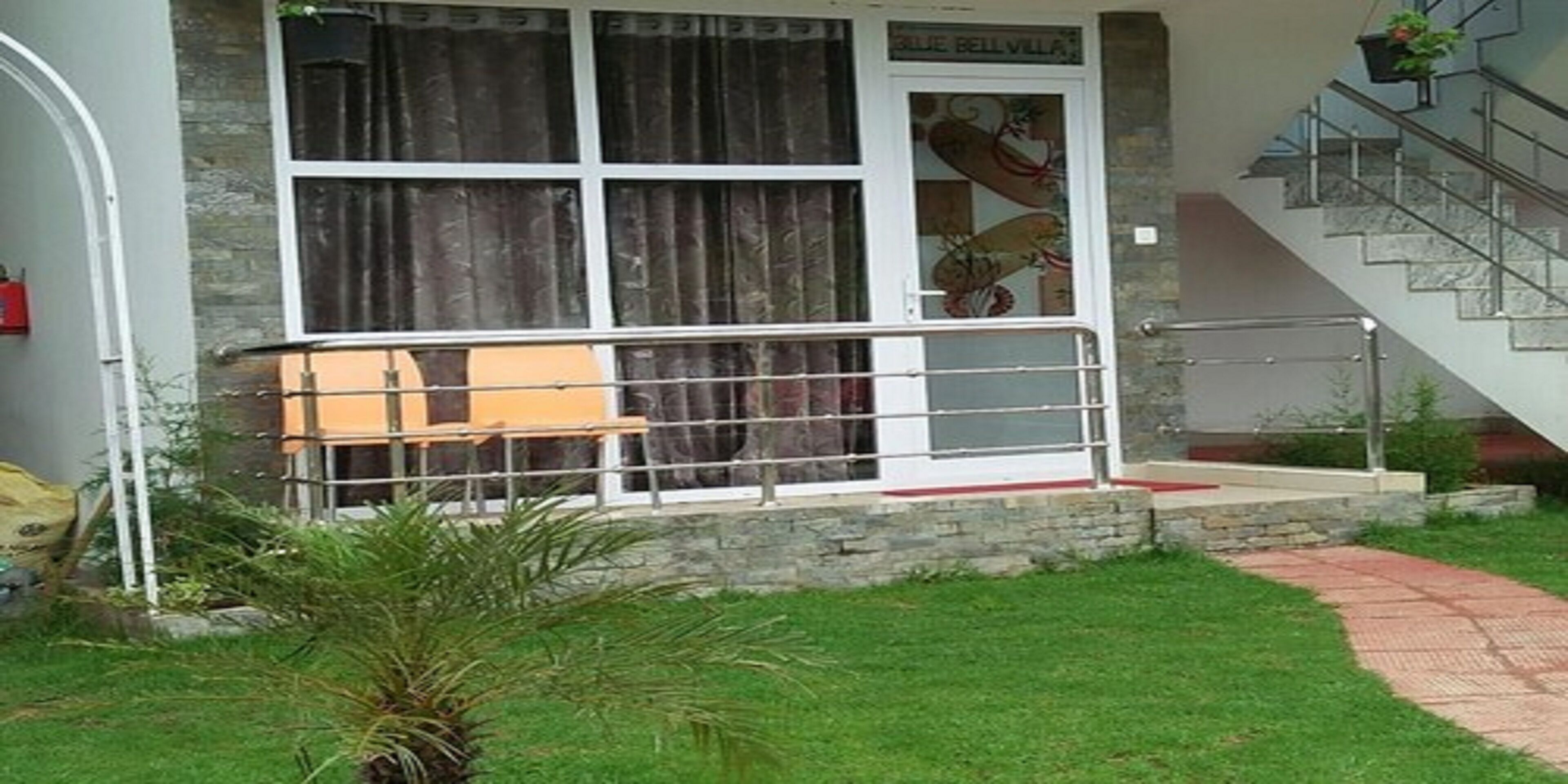 A building with a stone facade, a staircase, and a small outdoor seating area.