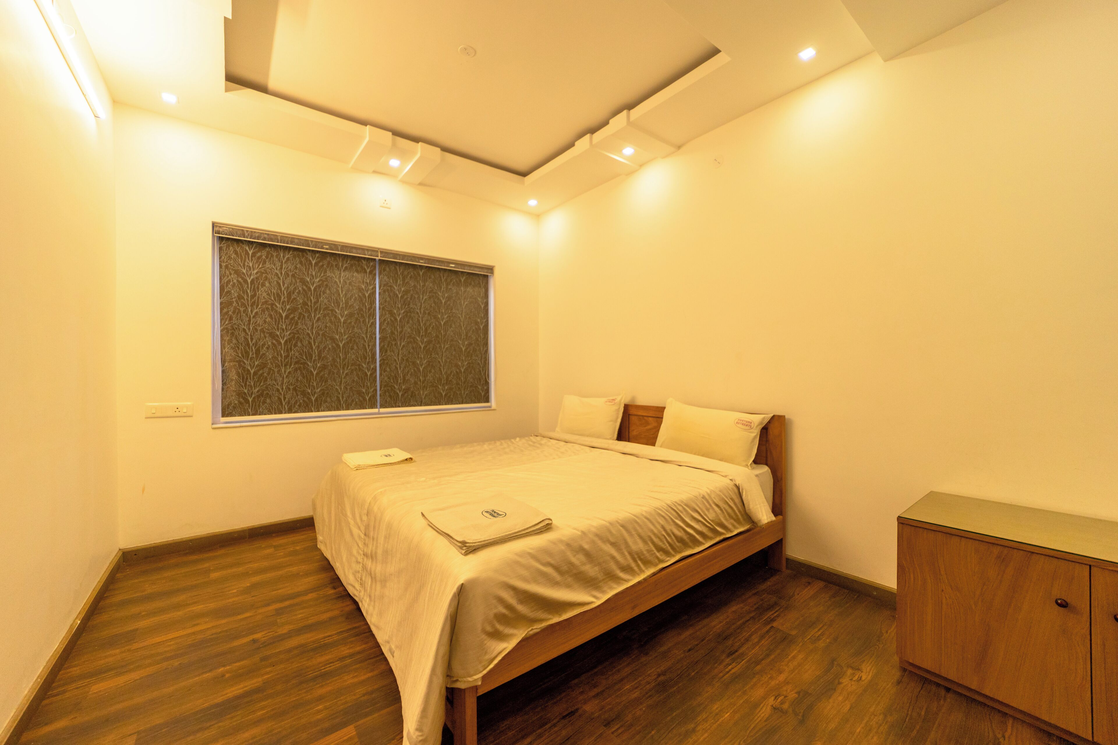 Une chambre à coucher avec un lit, une fenêtre, un plancher en bois et une armoire.