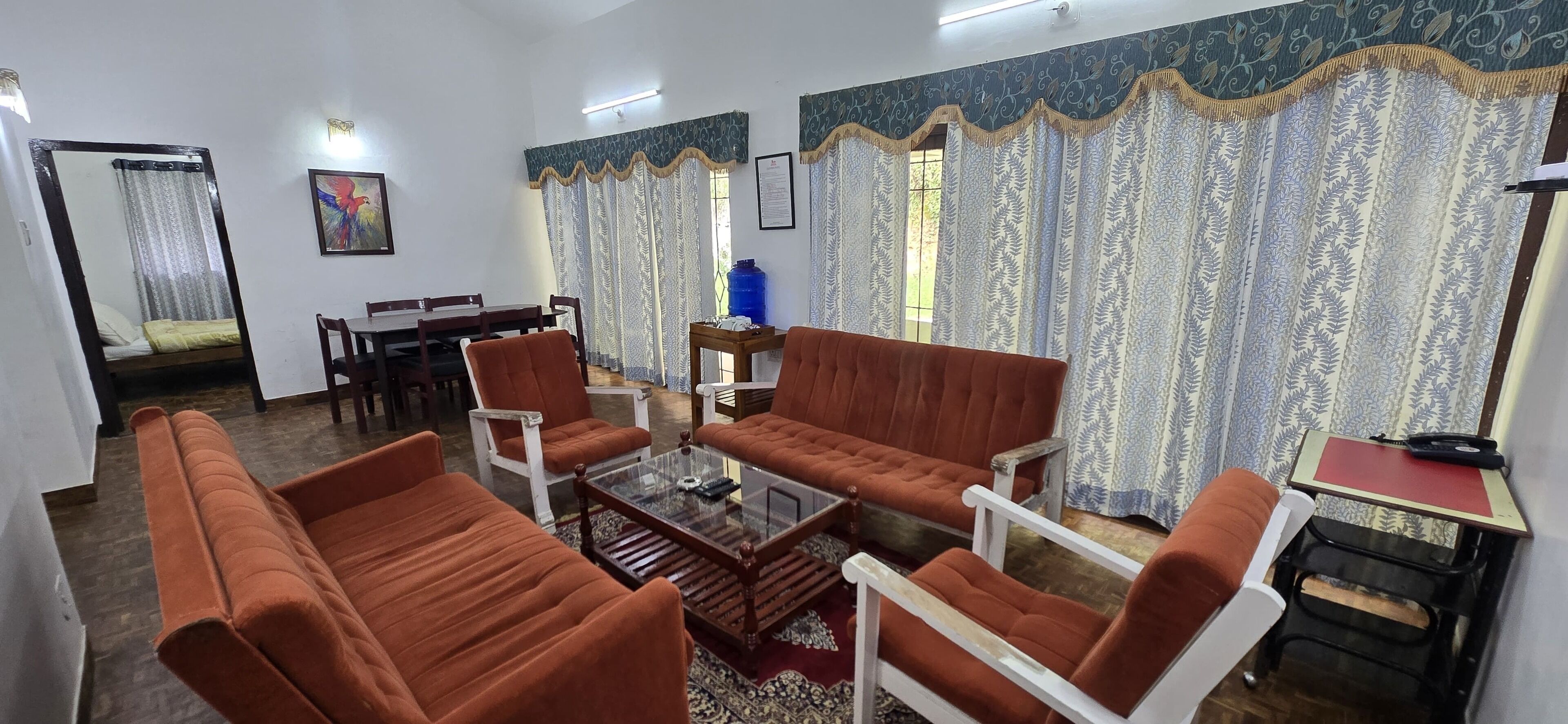 A living room with a sofa, chairs, a coffee table, and a dining area with a table and chairs.