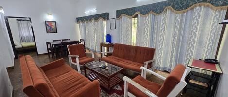 A living room with a sofa, chairs, a coffee table, and a dining area with a table and chairs.
