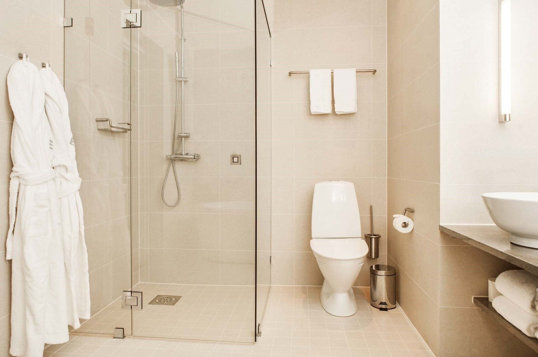 Un baño moderno con ducha de vidrio, inodoro y lavamanos.