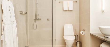 Un baño moderno con ducha de vidrio, inodoro y lavamanos.