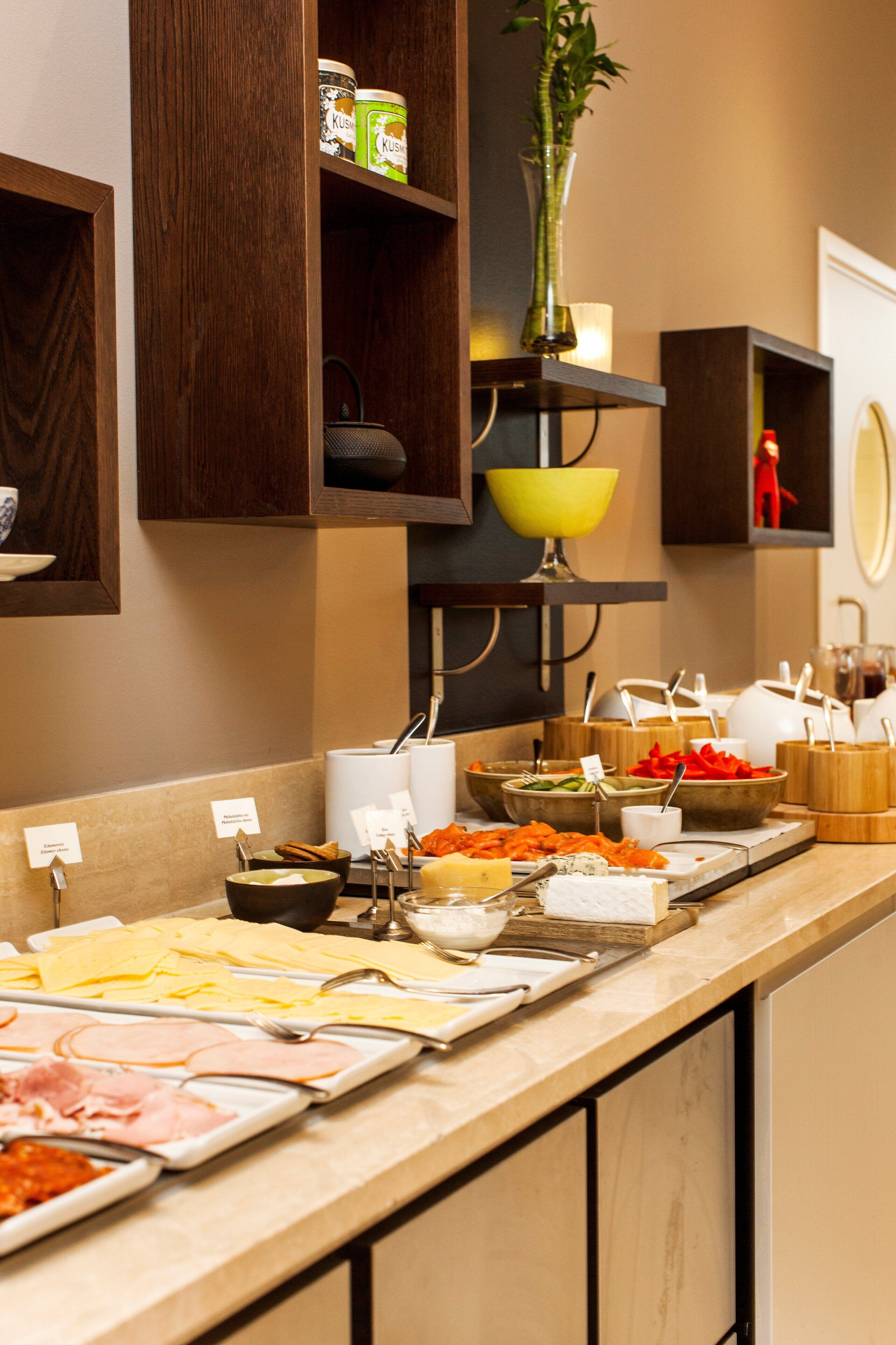 A buffet setup with various food items and utensils.
