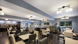 A spacious restaurant with multiple dining tables and chairs, a bar area, and large windows providing natural light. - Best Western Plus Mountain View Auburn Inn (Auburn)