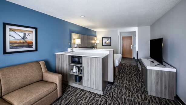 A hotel room with a kitchenette, a sofa, a TV, and a bathroom. - Best Western Plus Mountain View Auburn Inn (Auburn)