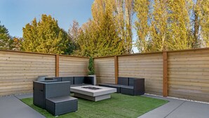 An outdoor patio with a sectional sofa, a fire pit, and a small green area. - Best Western Plus Mountain View Auburn Inn (Auburn)