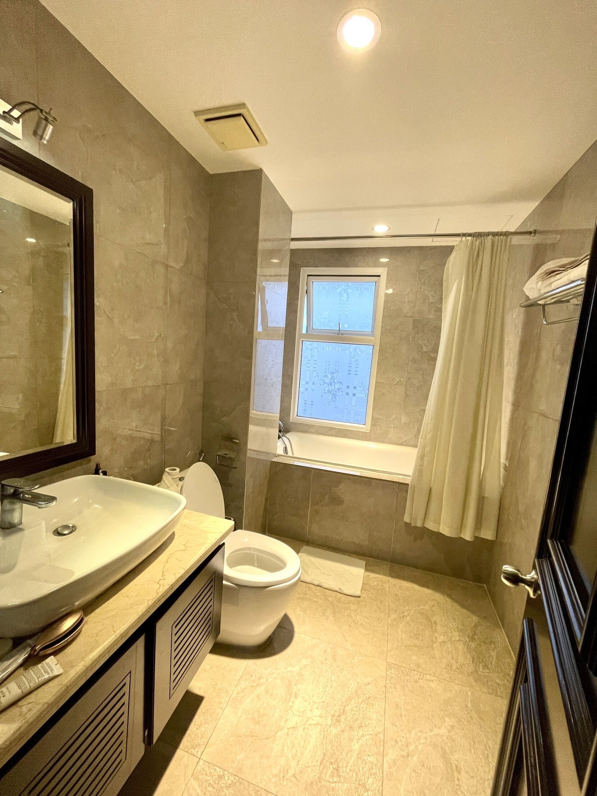 Een badkamer met een wastafel, toilet en bad.