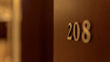 Une vue rapprochée d’une porte en bois portant le numéro 208.