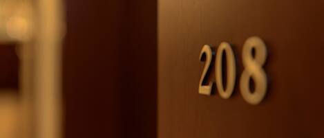 A close-up of a wooden door with the number 208 on it.