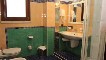 A bathroom with a toilet, sink, and shower.
