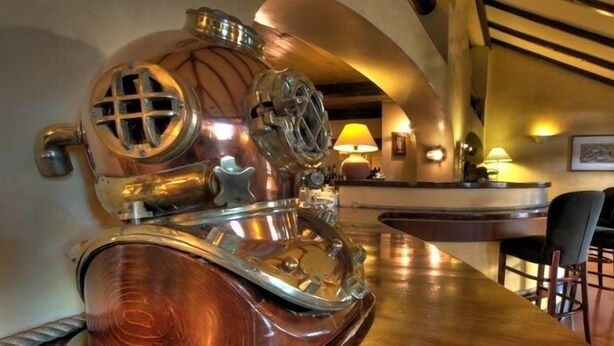 A bar area with copper fixtures, a reception desk, and bar stools. - Cala del Porto (Vibo Valentia)