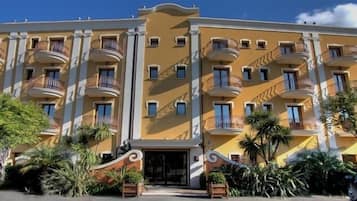 Stunning hotel building with ornate balconies and lush greenery.