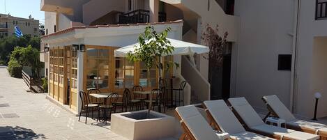 A hotel with outdoor seating and lounge chairs.