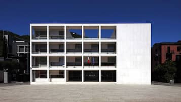 Un edificio moderno de varios pisos con fachada plana, ventanas amplias y balcones.