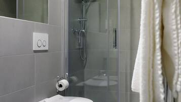 Ein modernes Badezimmer mit Duschkabine, Toilette und Waschbecken.