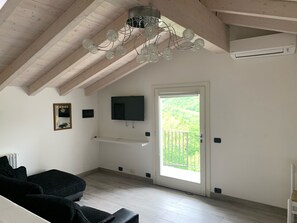 Suite estudio Deluxe | Área de sala de estar | Televisión de pantalla plana de 36 pulgadas con canales digitales 