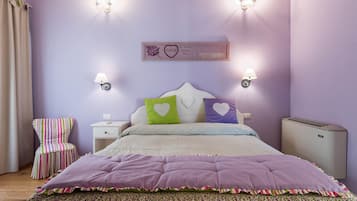 Un dormitorio con una cama, una silla, mesitas de noche y lámparas fijadas a la pared.