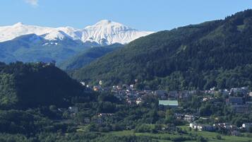 A town nestled in a valley with snow-capped mountains in the background.
