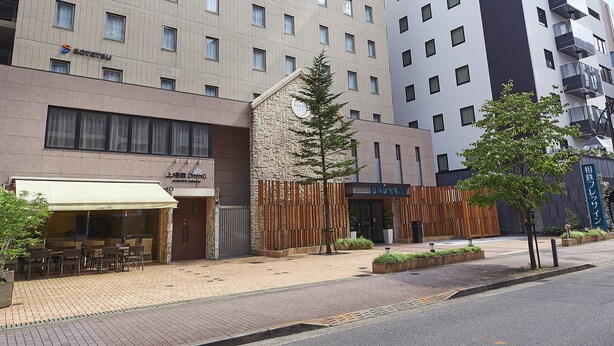A hotel with multiple floors, a prominent 'FRESNIN' sign, and a ground-level restaurant with outdoor seating. - Sotetsu Fresa Inn Tokyo Tamachi (Tokyo)