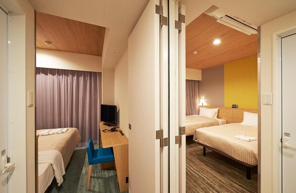 A hotel room with two beds, a desk with a chair, a television, and a bathroom door. - Sotetsu Fresa Inn Tokyo Tamachi (Tokyo)