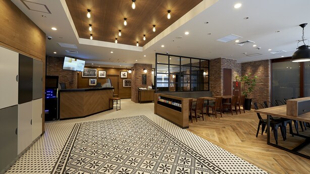 A modern interior with a reception desk, seating area, and patterned floor. - Sotetsu Fresa Inn Nihombashi Kayabacho (Tokyo)