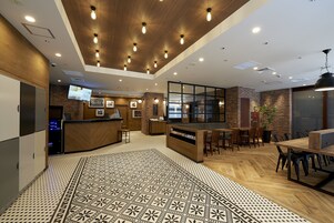 Un interior moderno con mostrador de recepción, zona de estar y suelo estampado.