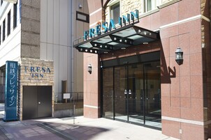 Entrada de hotel con un cartel que dice "FRESA INN" y un cartel más pequeño debajo.