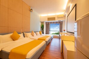 Une chambre d’hôtel avec deux lits, un bureau et une grande fenêtre.