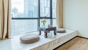 A room with a large window, a small table with a vase and teapot, and two round cushions on a marble bench. - Lavande International ApartHotel US Consulate General Guangzhou Zhujiang New Town Metro Branch - Free Shuttle Bus to Canton Fair Complex During Canton Fair Period & Free VPN Internet Access (Guangzhou)