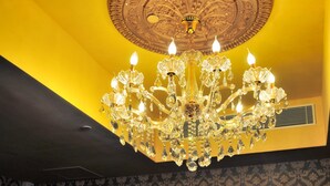 A restaurant with a chandelier, patterned wallpaper, and tables set for dining. - Ramada Grand Tsim Sha Tsui (Former Ramada Hong Kong Grand Tsim Sha Tsui) (Kowloon)