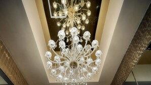 A modern lobby with a large chandelier, marble flooring, and a reception desk. - Ramada Grand Tsim Sha Tsui (Former Ramada Hong Kong Grand Tsim Sha Tsui) (Kowloon)