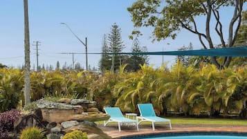 Een buitenzwembad, parasols voor strand/zwembad
