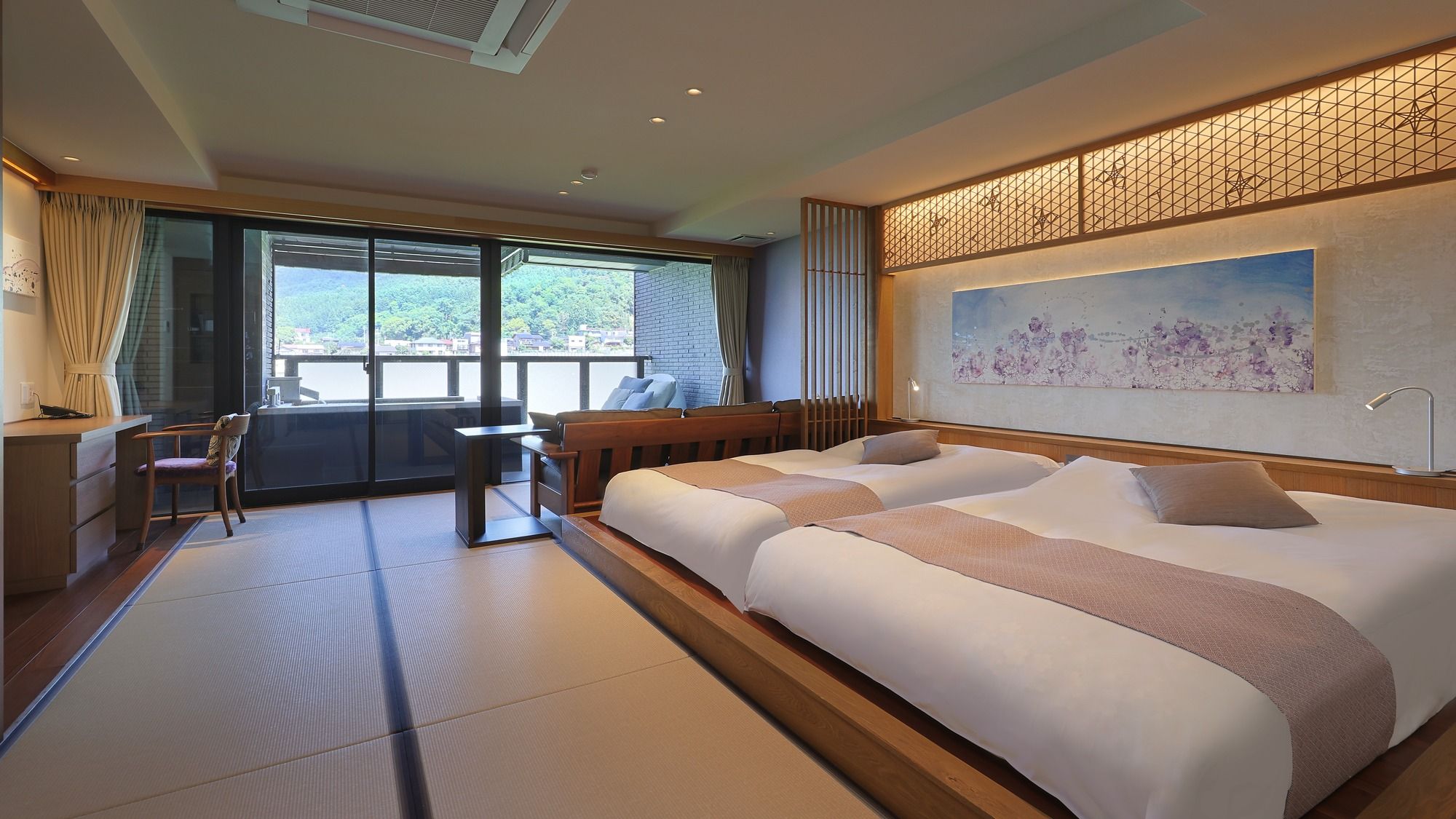 Une chambre d’hôtel avec un grand lit, un bureau et une vue sur l’extérieur.