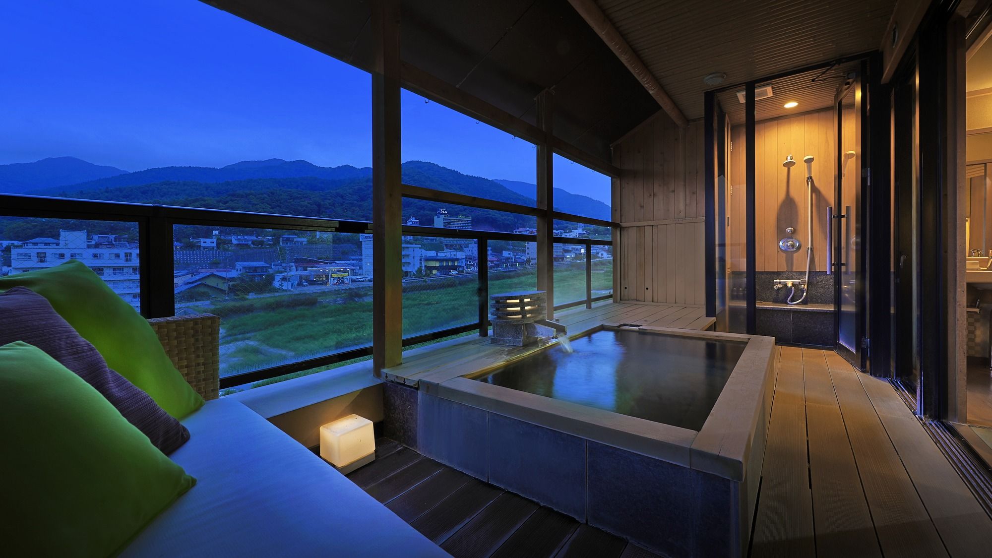 Un jacuzzi con vistas a un paisaje urbano y montañas.