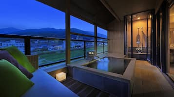 Un jacuzzi con vistas a un paisaje urbano y montañas.