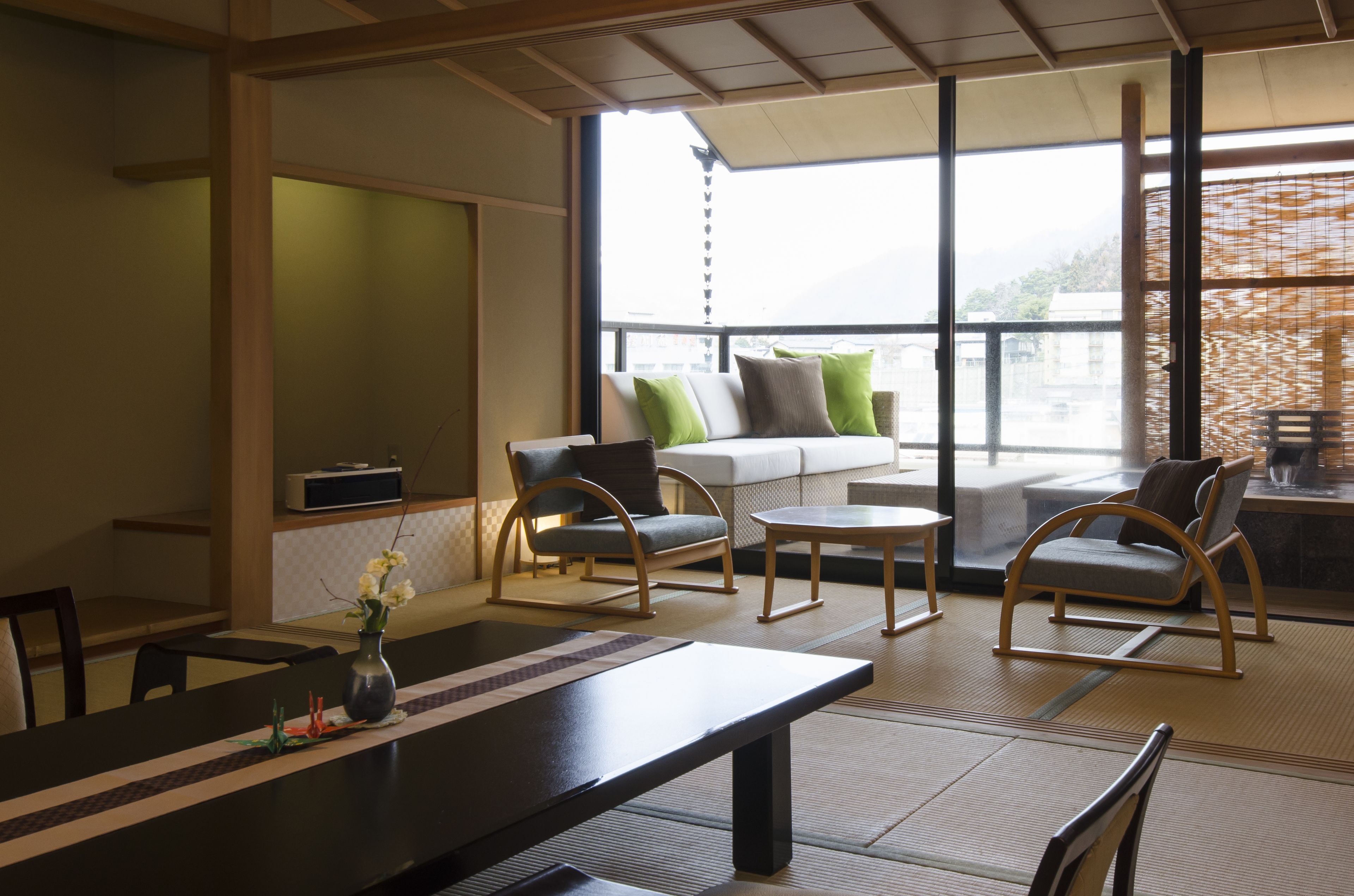 A modern room with a sofa, chairs, a table, and a large window.