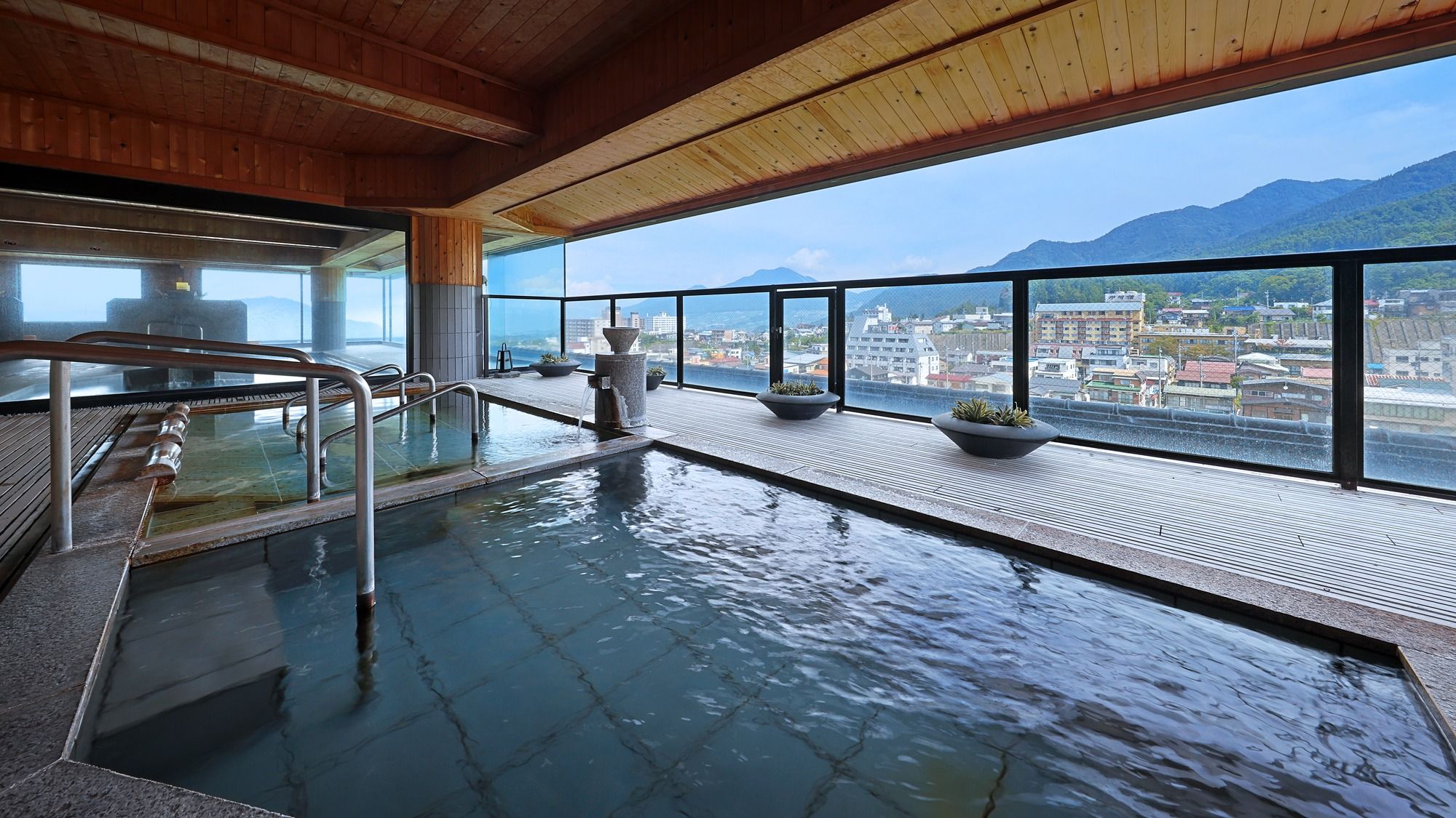 Una piscina interior con vistas a un paisaje urbano y montañas.