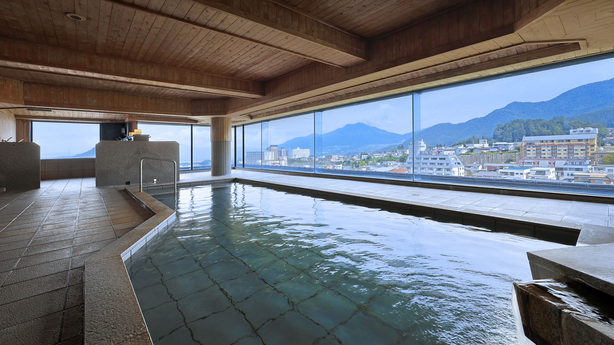 Una piscina al coperto con vista su montagne e edifici.