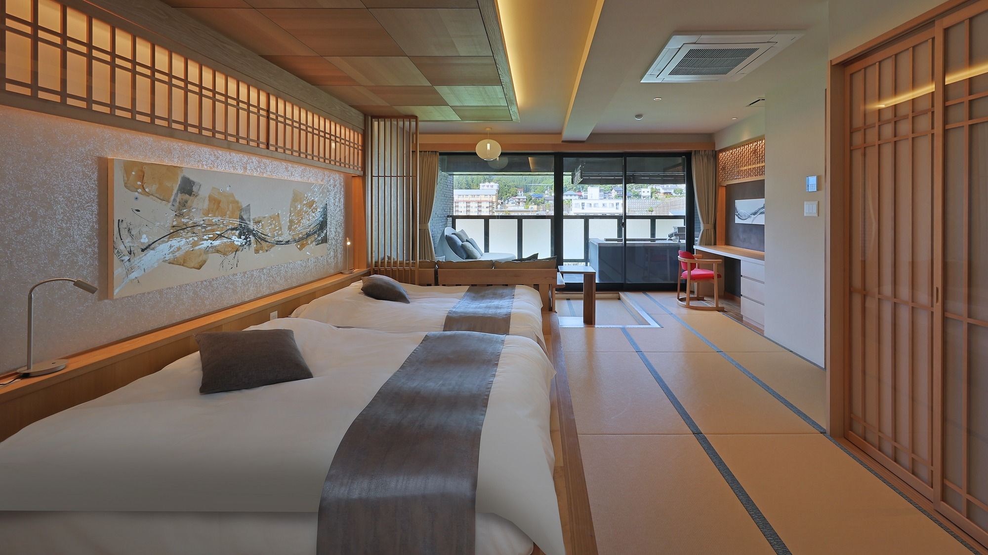 Une chambre d’hôtel avec deux lits, une grande fenêtre et des portes coulissantes de style japonais traditionnel.
