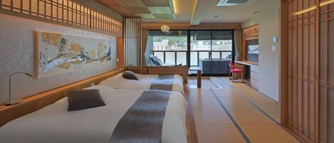 A hotel room with two beds, a large window, and traditional Japanese sliding doors.