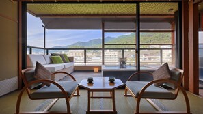 A balcony with a sofa and chairs, a table, and a view of a cityscape and mountains. - Aburaya Tosen (Yamanouchi)