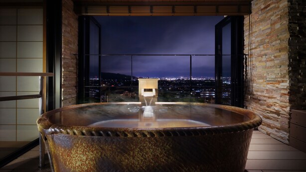 Un jacuzzi con vista a un paisaje urbano nocturno.