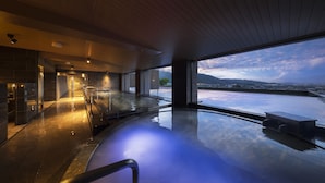 Una piscina interior moderna con vistas panorámicas de una ciudad y montañas.