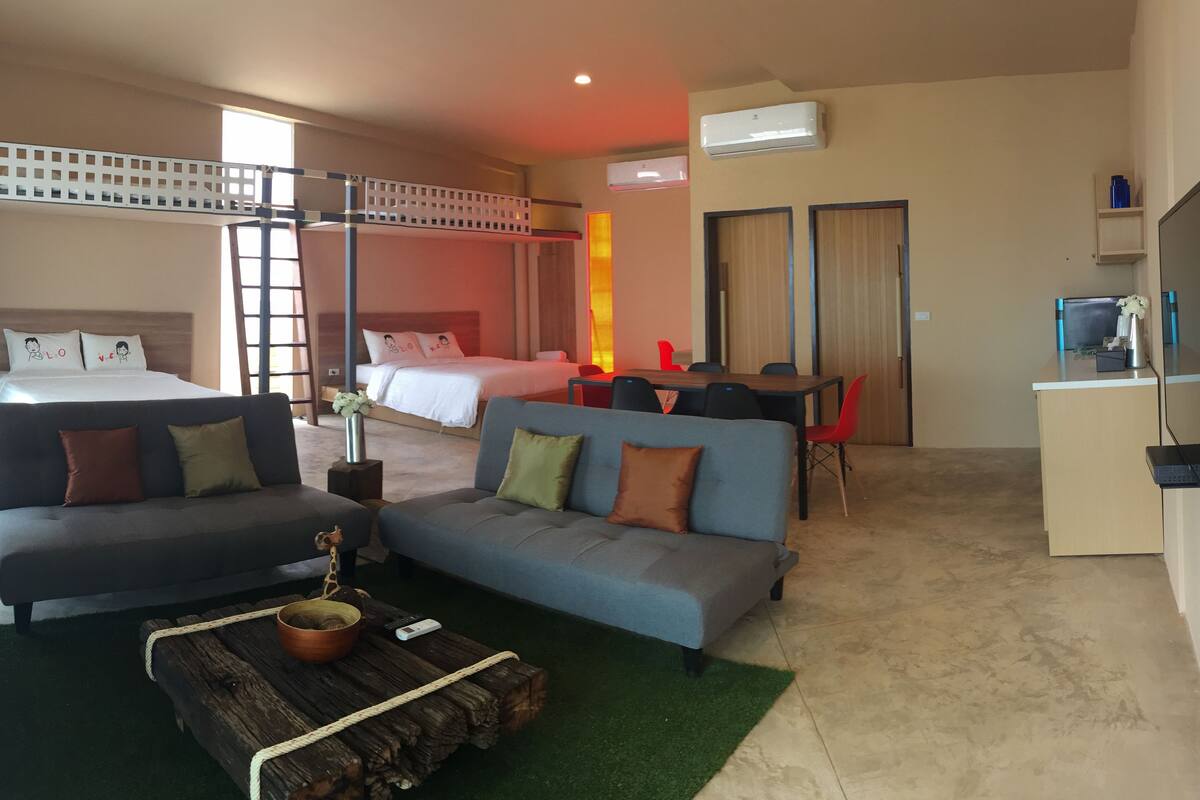 Ein Hotelzimmer mit Bett, Sofa, Schreibtisch und Fernseher.
