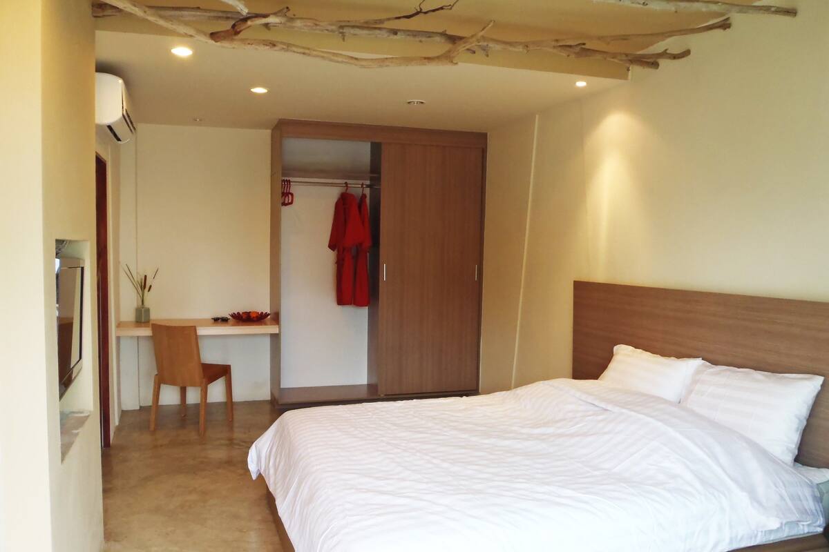 Ein Schlafzimmer mit einem großen Bett, einem Holztisch und einem Stuhl.