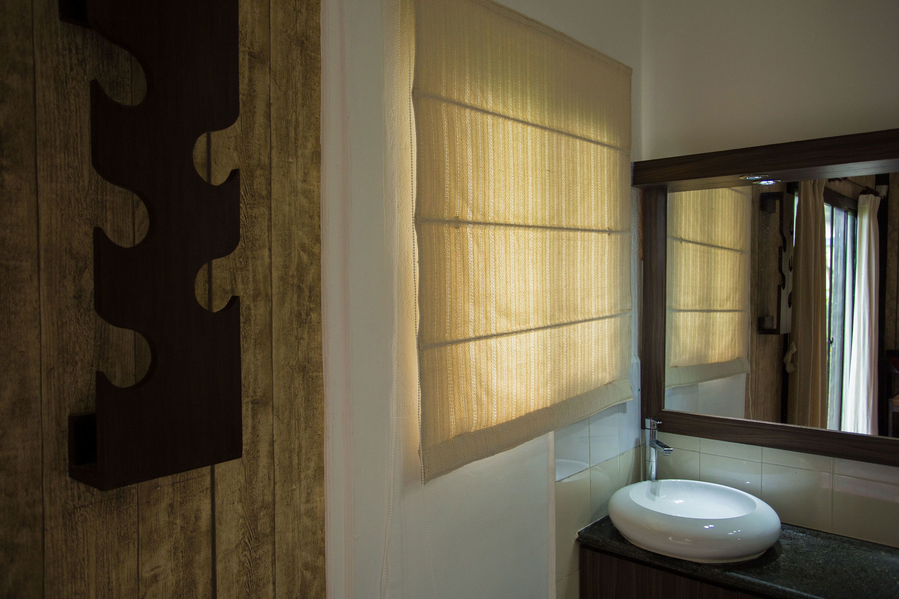 A bathroom with a wooden wall panel, a large mirror, and a white sink.