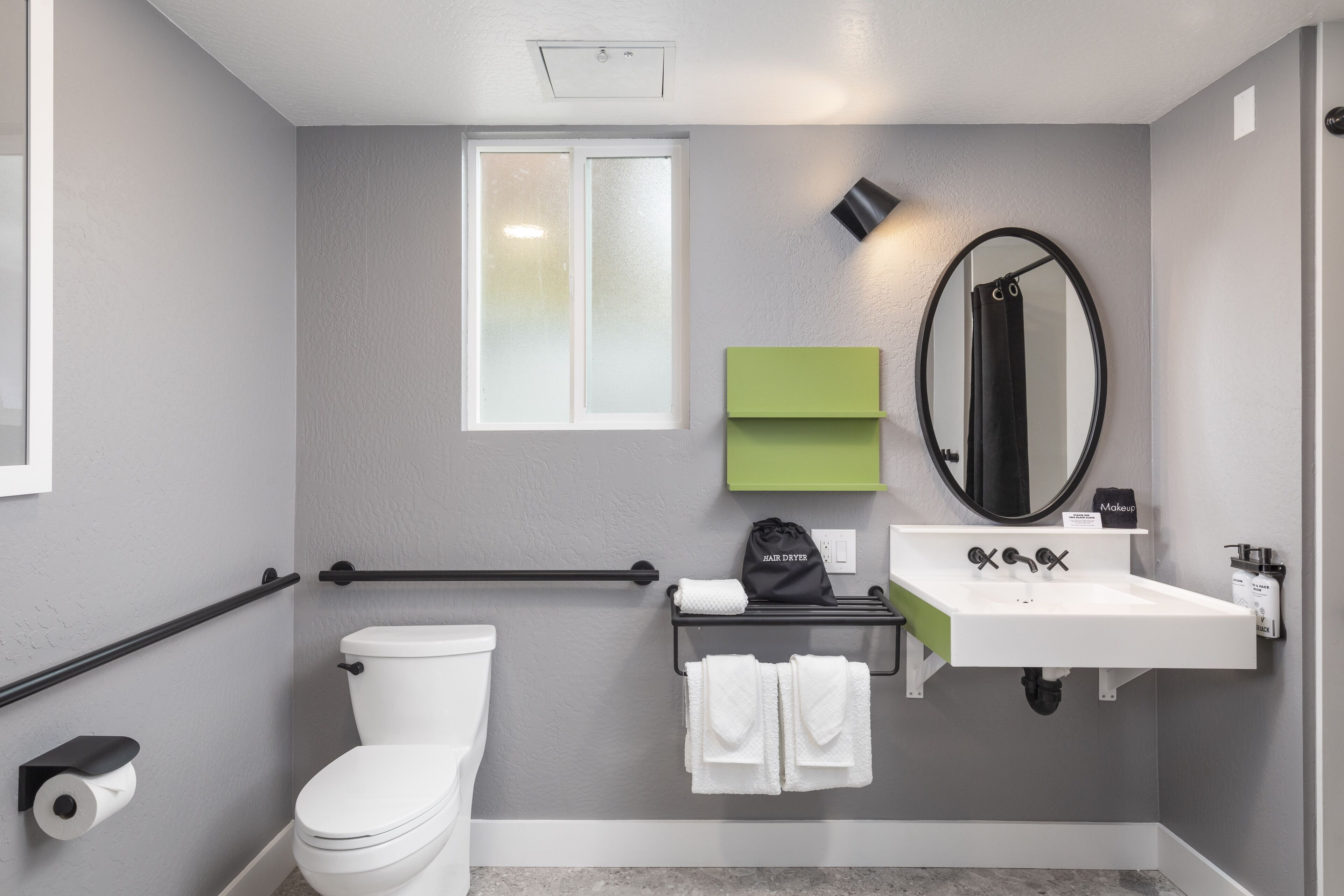 Un baño moderno con inodoro, lavabo y perchero para toallas.